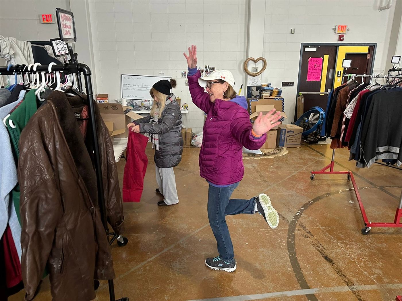 Racks of donated clothing organised by size in the clothing closet