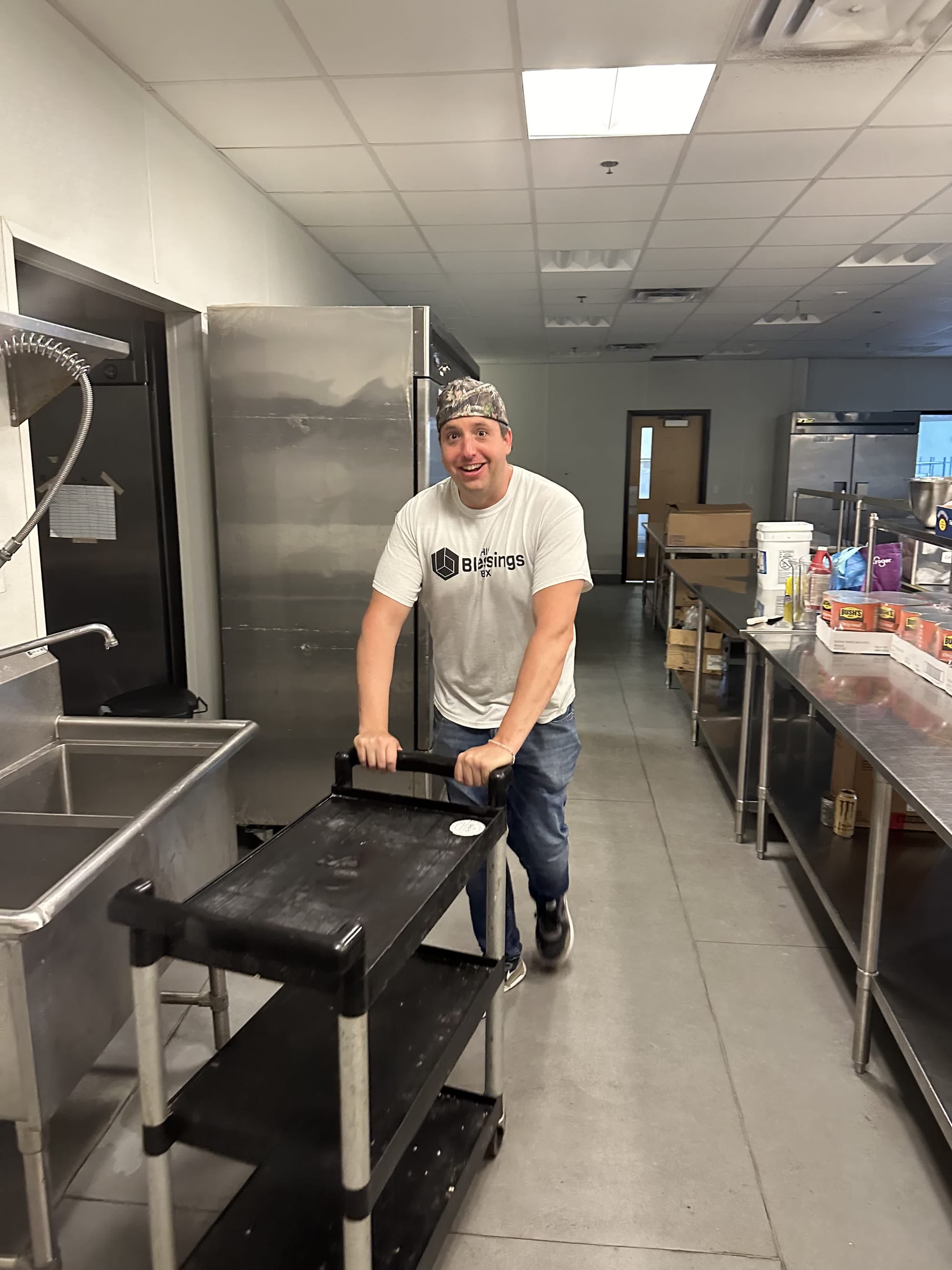 A His Blessings Box volunteer wheeling a cart through the kitchen