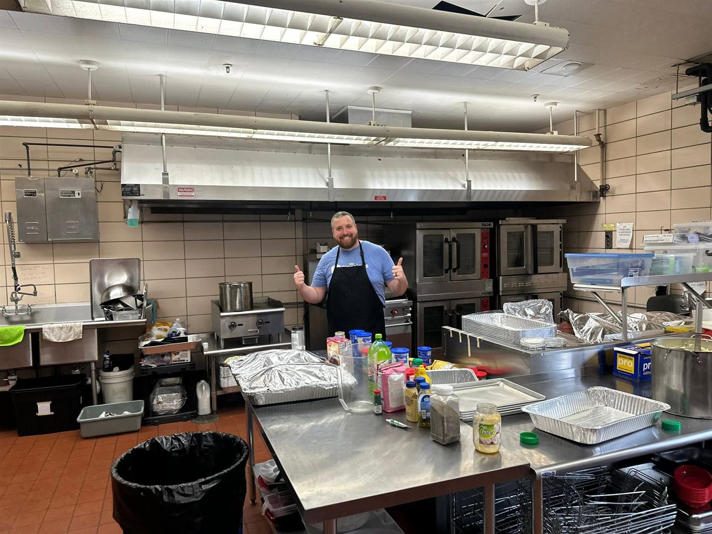 A volunteer cooking in the commercial kitchen at Sanctuary Church